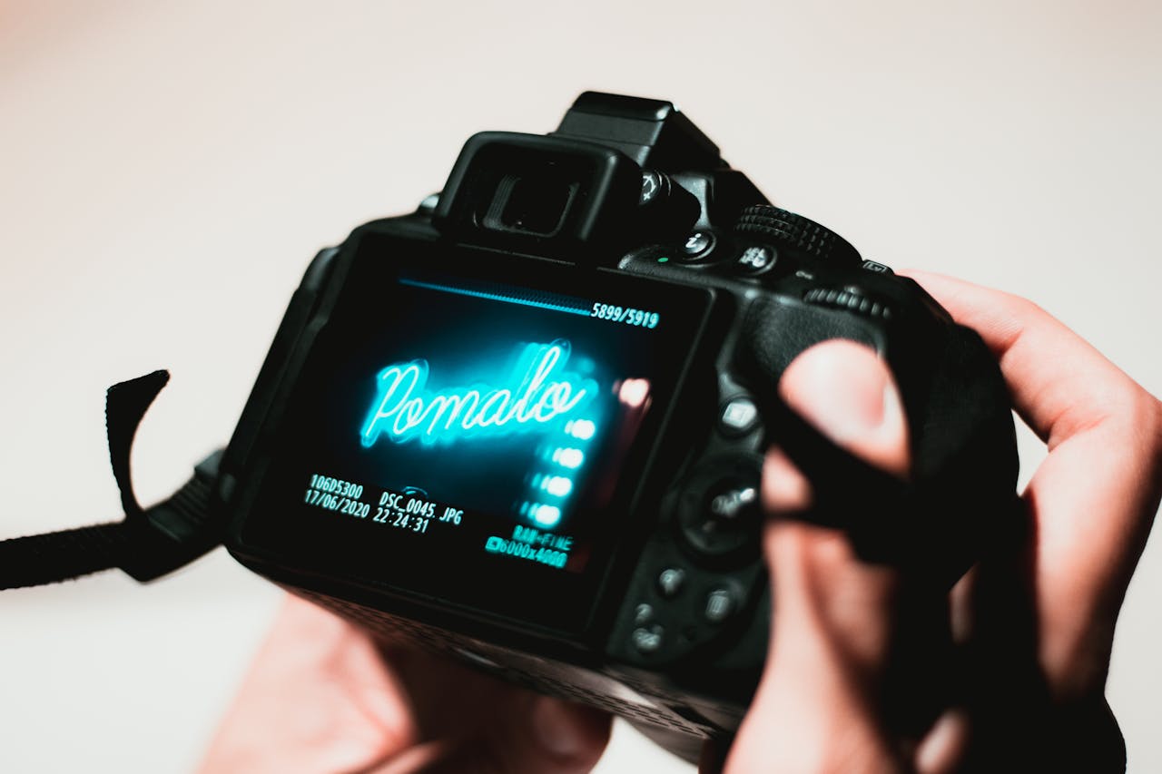 Home A DSLR camera screen displaying an image with hands holding the device, highlighting photography process.